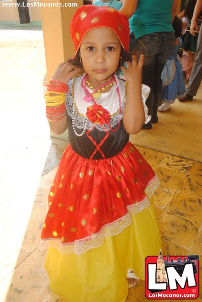 a little girl dressed in indian clothing waving