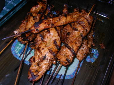 a plate with several skewers of meat on it