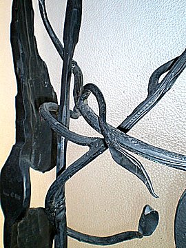 metal sculpture with curved designs hanging on the wall