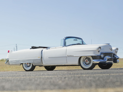 an old classic white car on the road