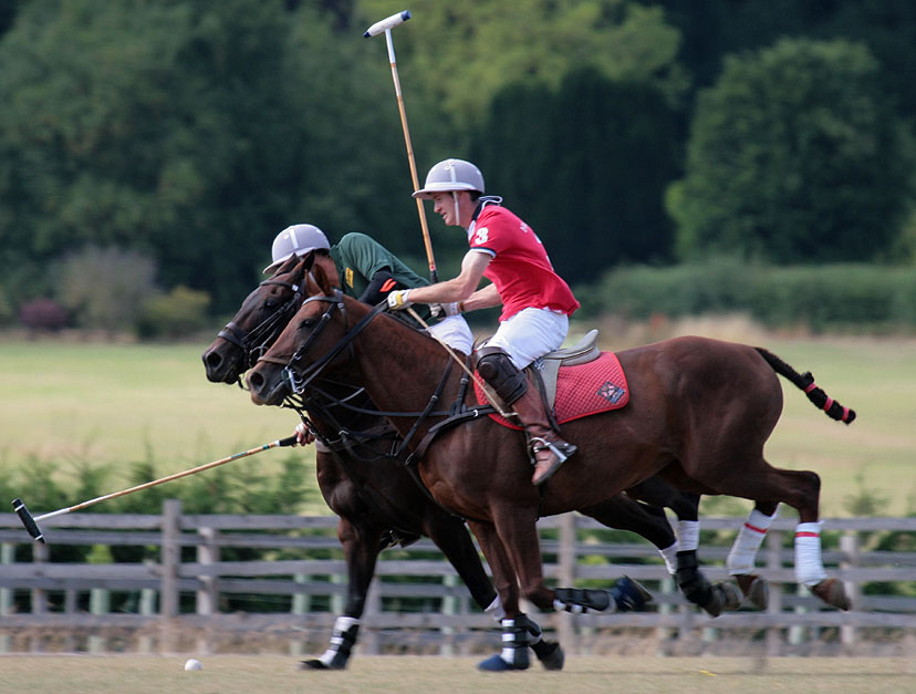 two polo players on horses playing polo outside