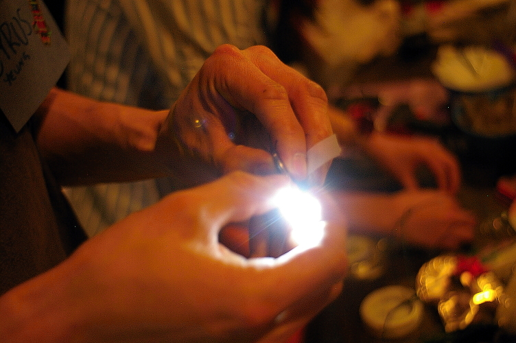 several people holding a lighter in their hands