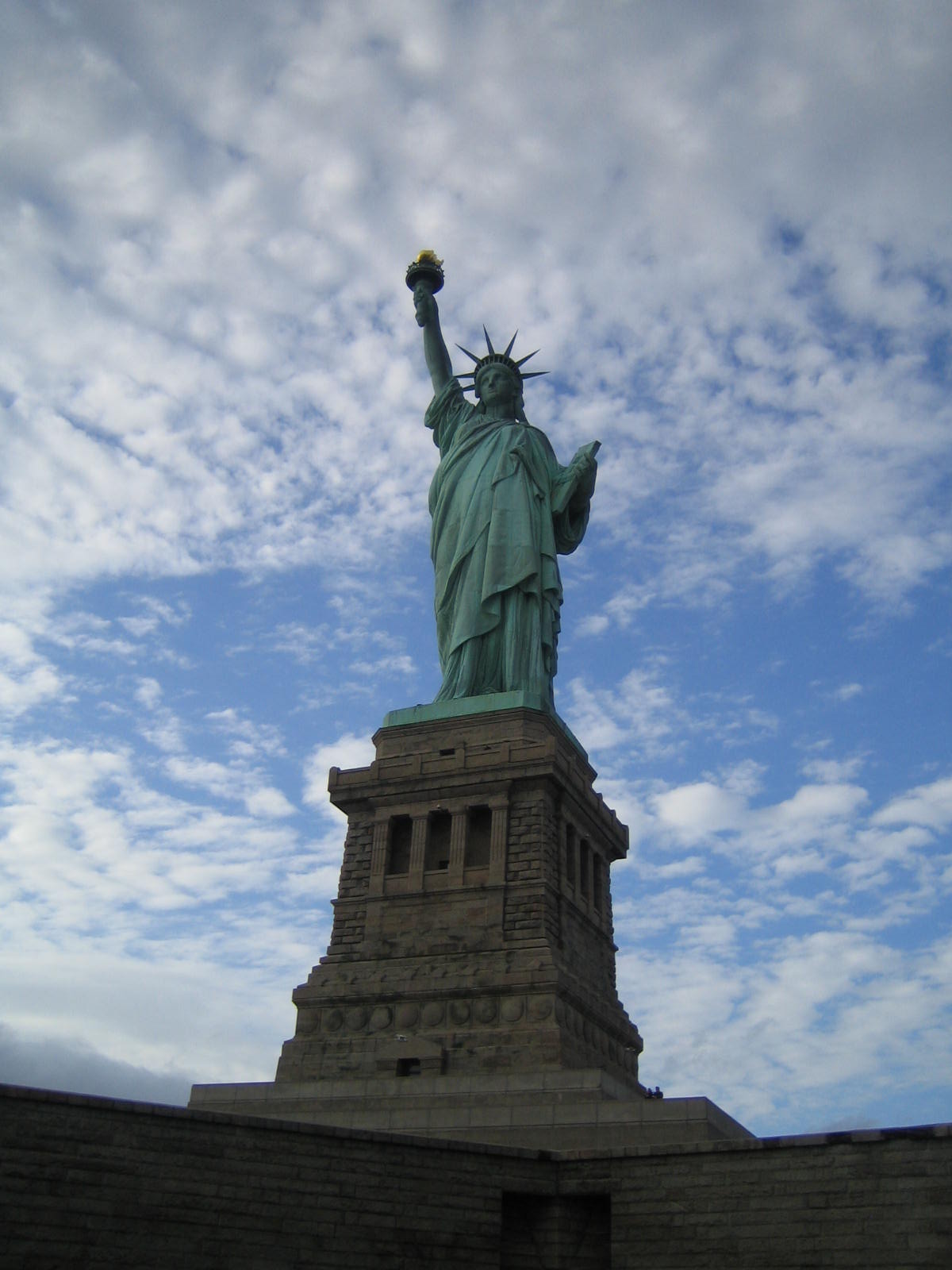a statue of liberty against a cloudy blue sky