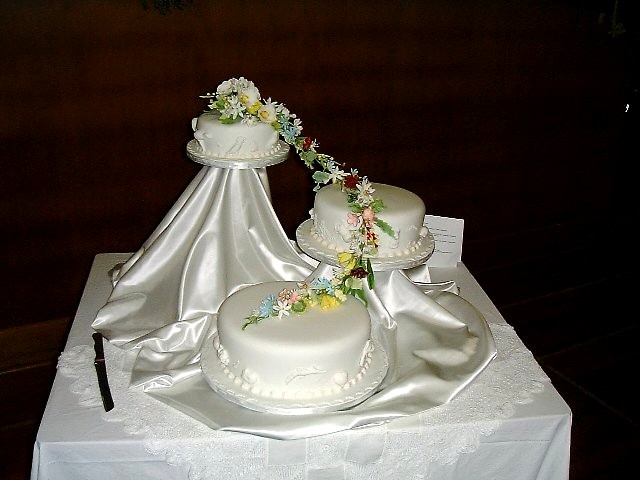 a table covered with two wedding cakes on top of a white cloth