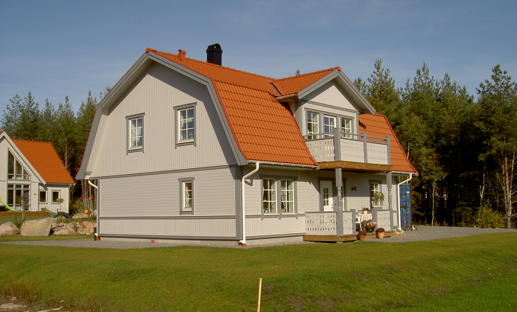 the front view of a white and gray house with orange roofing