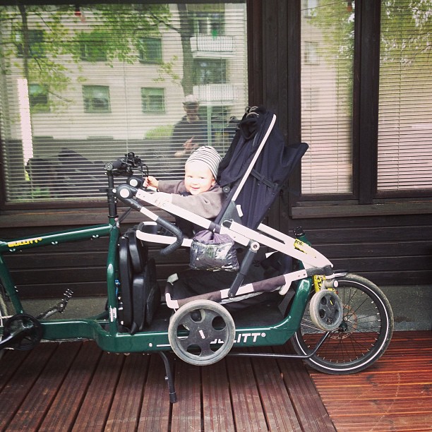 a child is sitting in a little bicycle cart