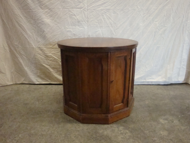 a small round wooden cabinet sitting on a white sheet