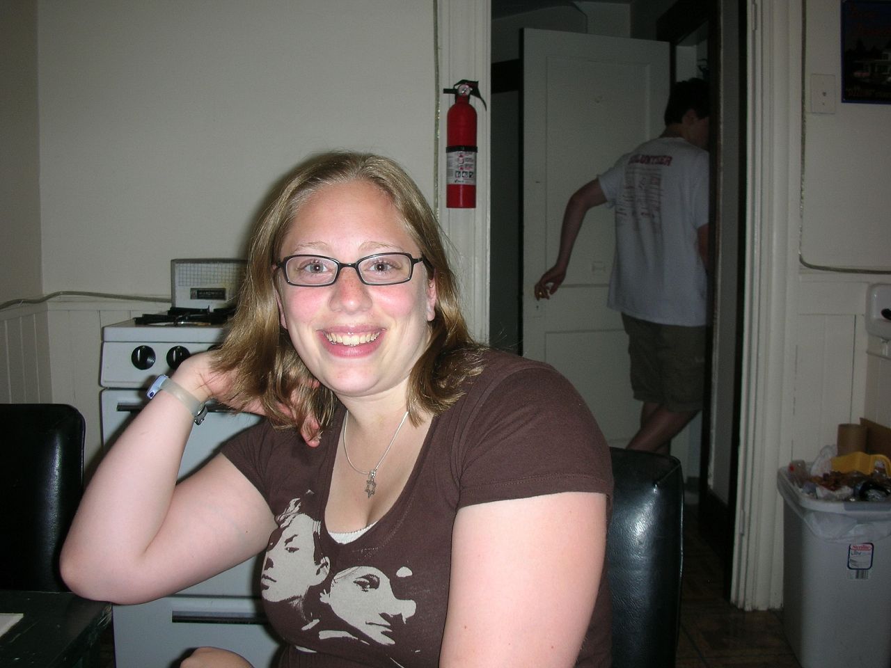 a woman sitting in a kitchen smiling at the camera