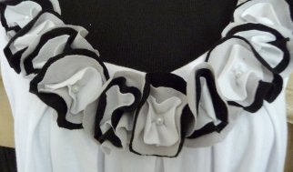 a white top with black ruffles is on display