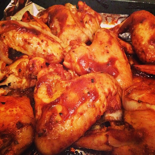 chicken wings covered with ketchup are shown in the foreground