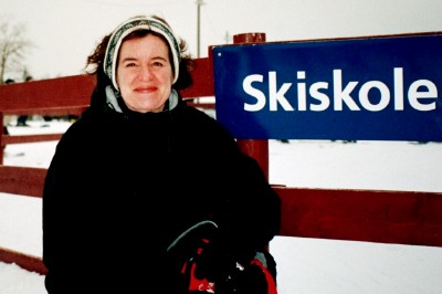 a woman is standing next to a ski pole in the snow