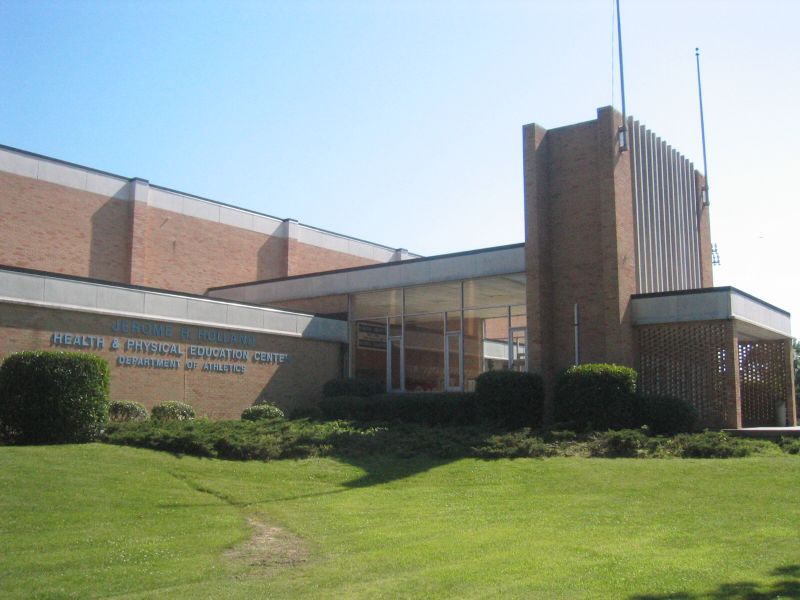 the front of a school with large green grass