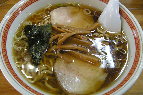 a bowl of chinese noodle soup with broccoli and some other meat
