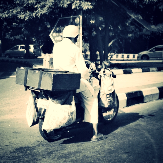 a man riding on the back of a motorcycle with luggage on it