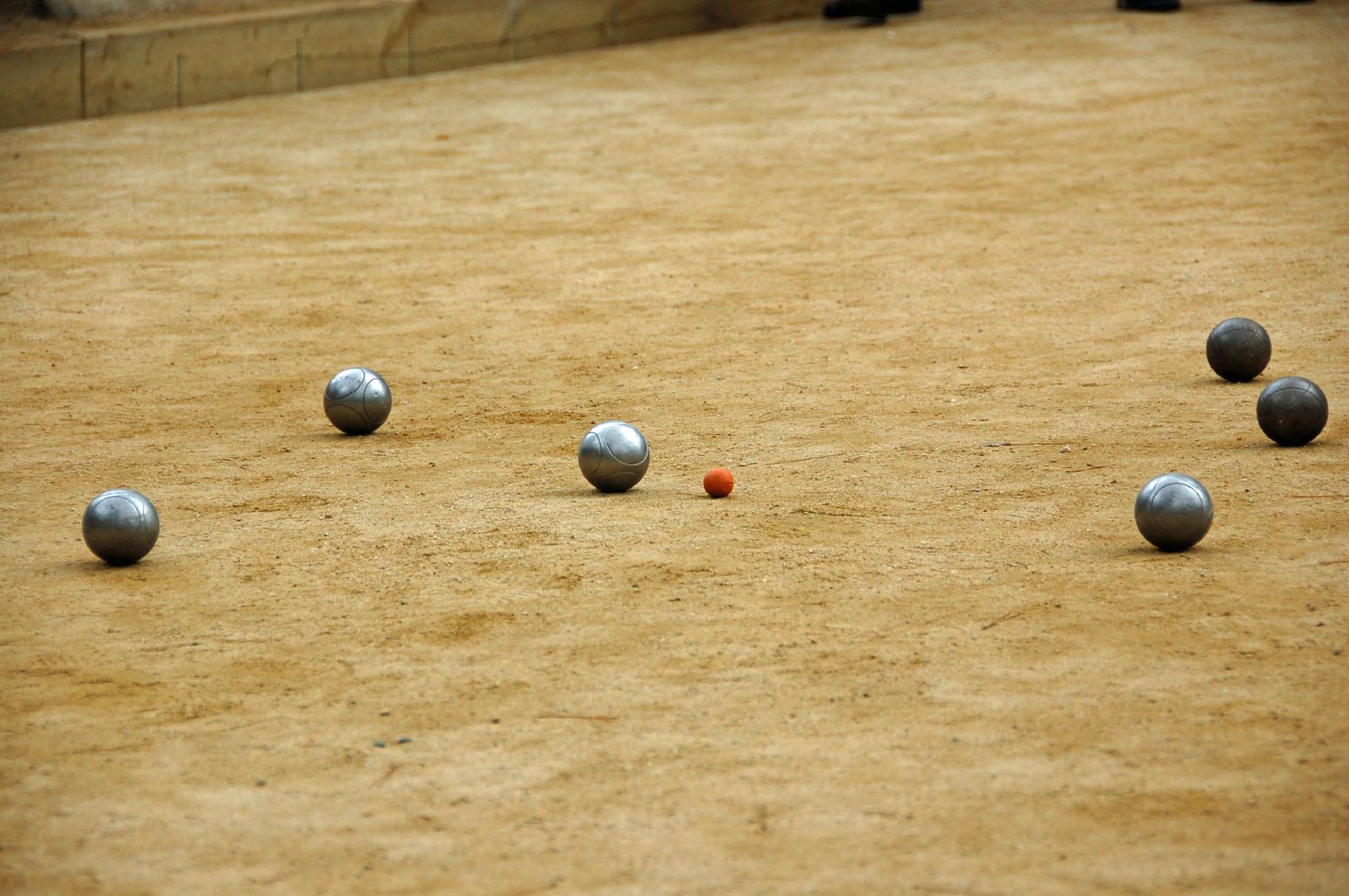 a group of silver balls in a sandy field