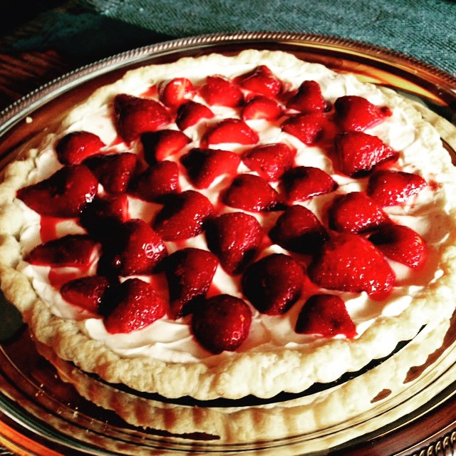 a pie sitting on top of a metal pan covered in strawberries