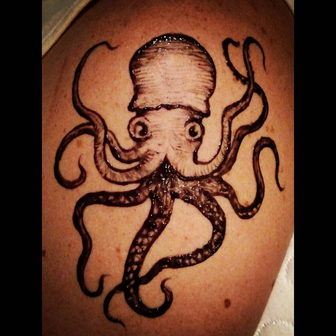 an octo tattoo on the back of a person's shoulder