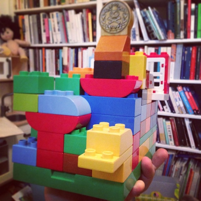 a stack of colorful toys in front of a bookcase