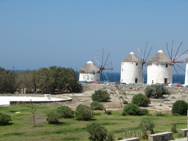 a number of small white windmills near a sea