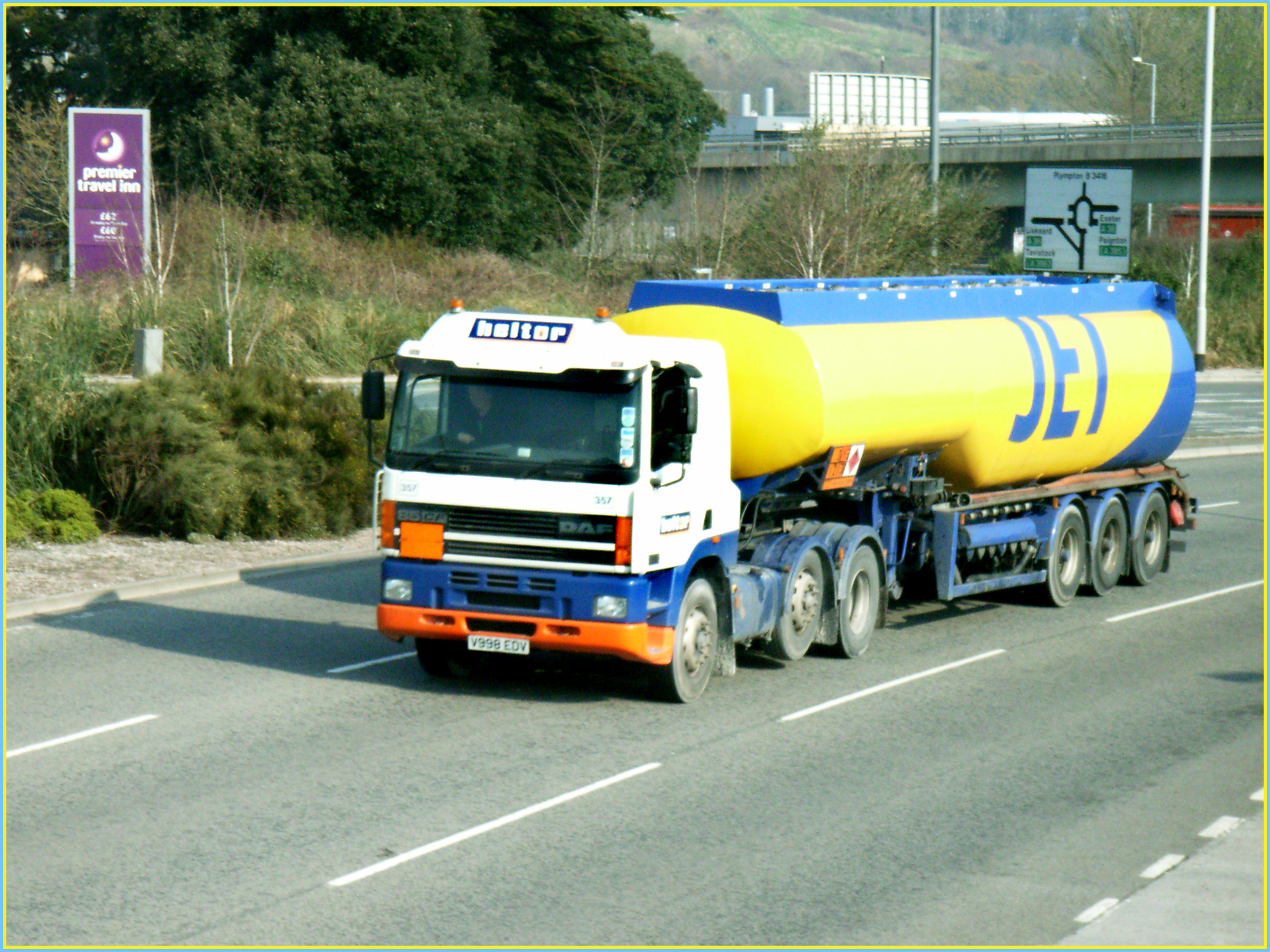 a big bright yellow fuel truck traveling down the road