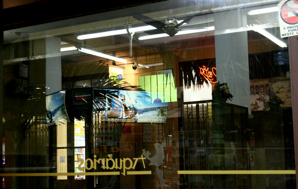 the shopfront window shows a woman on a surfboard