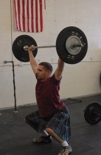 a man lifting weights while performing a squat exercise