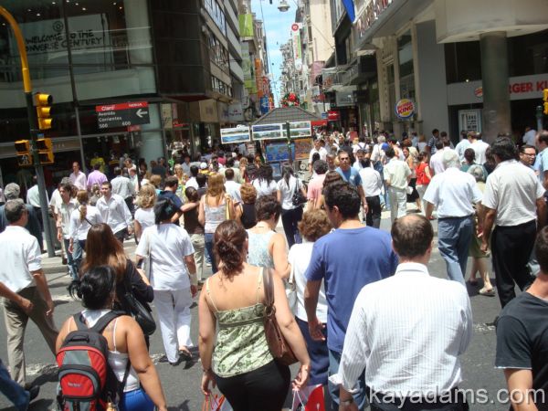 people are walking along a busy street crowded with pedestrians