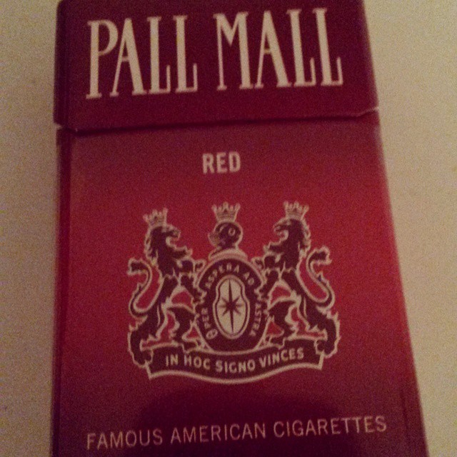 a red cigarette box sitting on top of a white wall