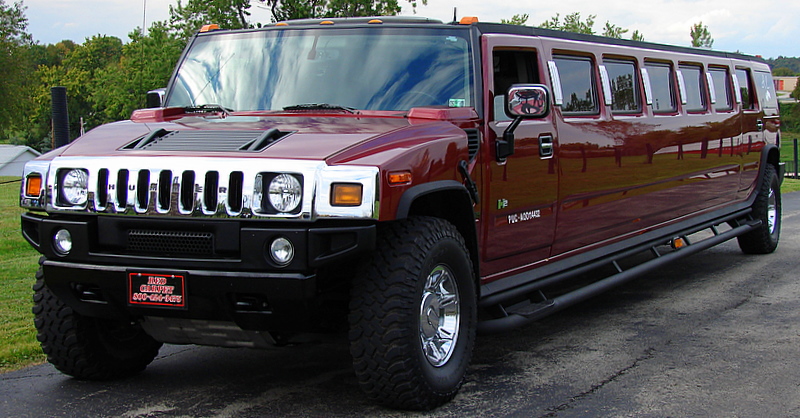 a maroon hummer vehicle parked in the driveway
