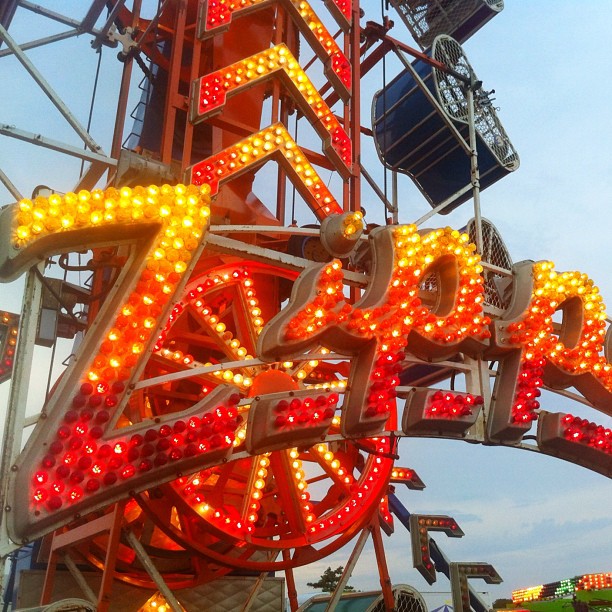 a carnival ride sign with the word fairground in front