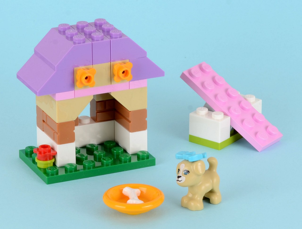 a pink and purple lego set next to a house