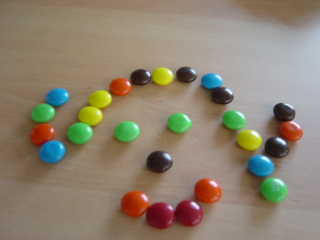 several multicolored candy candy beads are arranged in the shape of the letter o