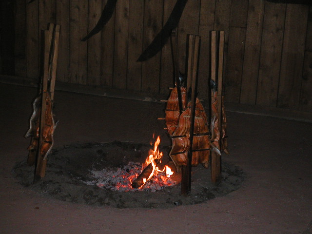 a fire burning inside of a fireplace in a wood pen