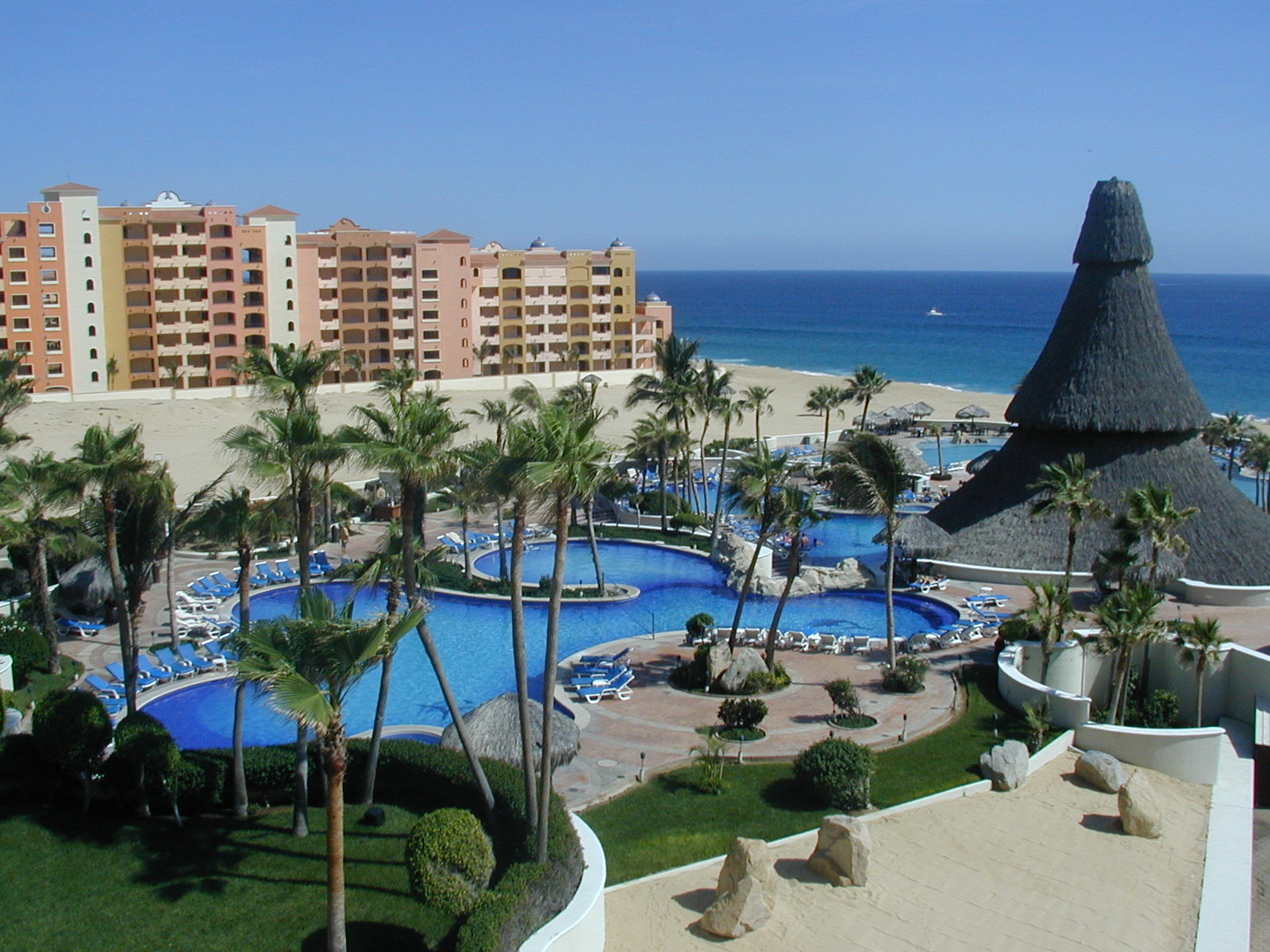 a large building near the beach next to an ocean