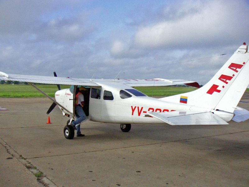 an airplane with the door open and a man in a suit exiting the door