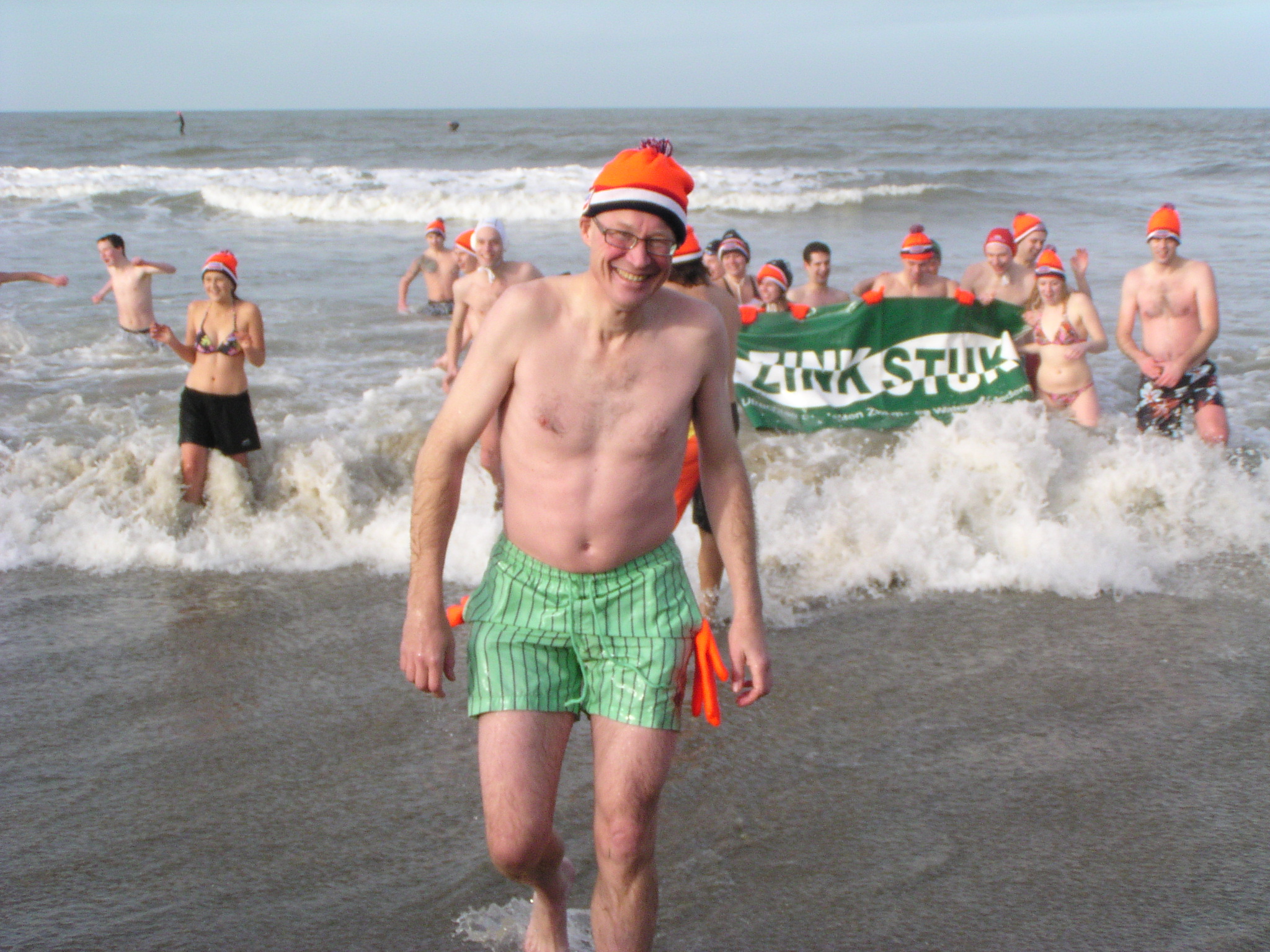 a man standing on the beach next to some people