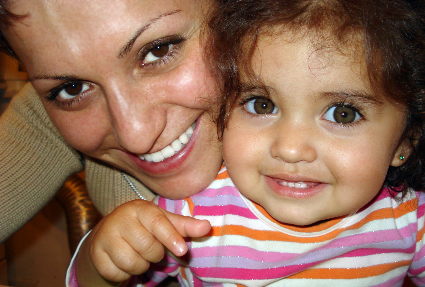 a beautiful young woman holding a little girl with brown eyes
