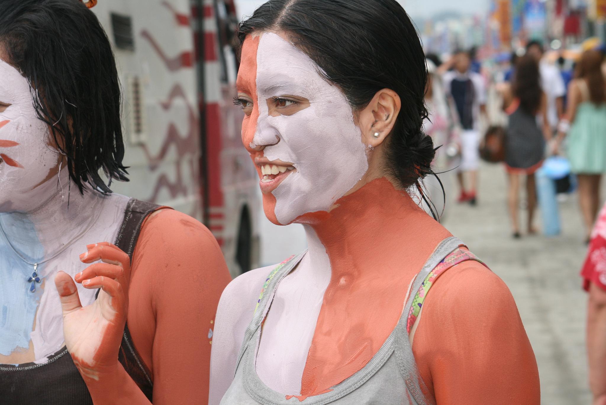 two woman painted orange and black near each other