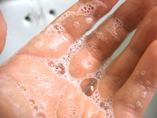 a hand with water droplets on it and a person's hand
