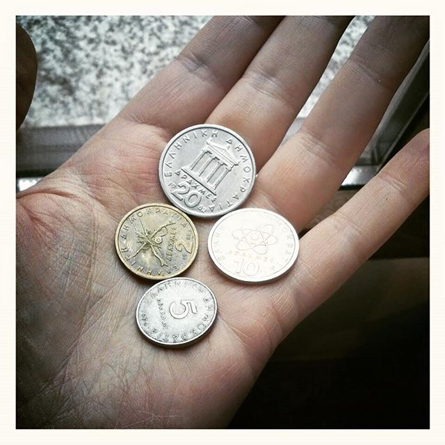 three coin pieces sit in a hand on top of a gray rug