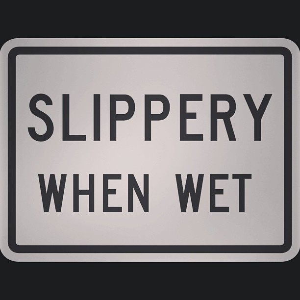 a slippery when wet sign placed on the wall