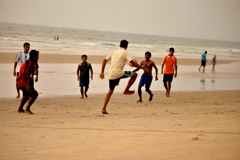 people on a beach playing with a ball