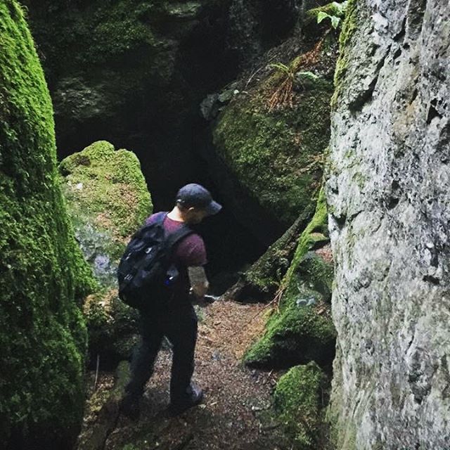 a person wearing a helmet hiking up some rocks