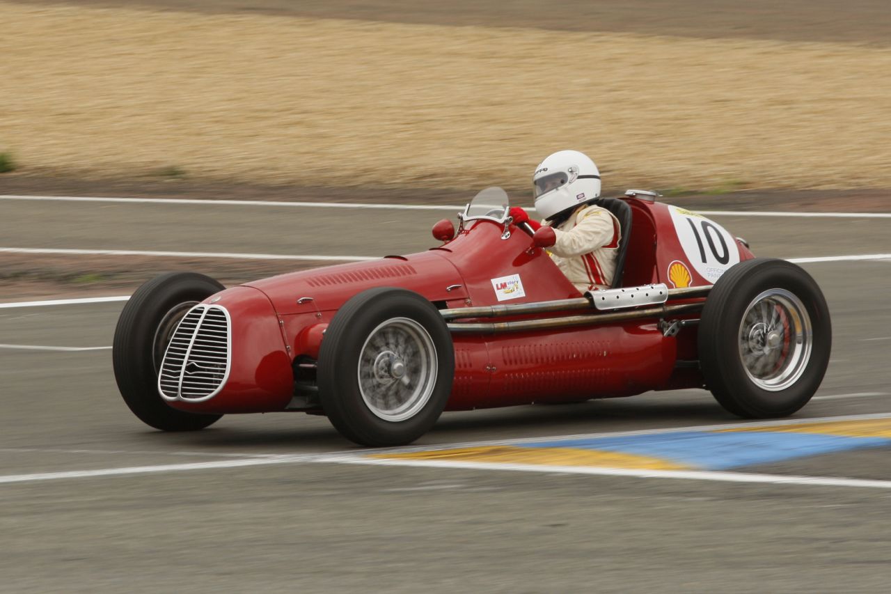 a man riding on the back of a red race car