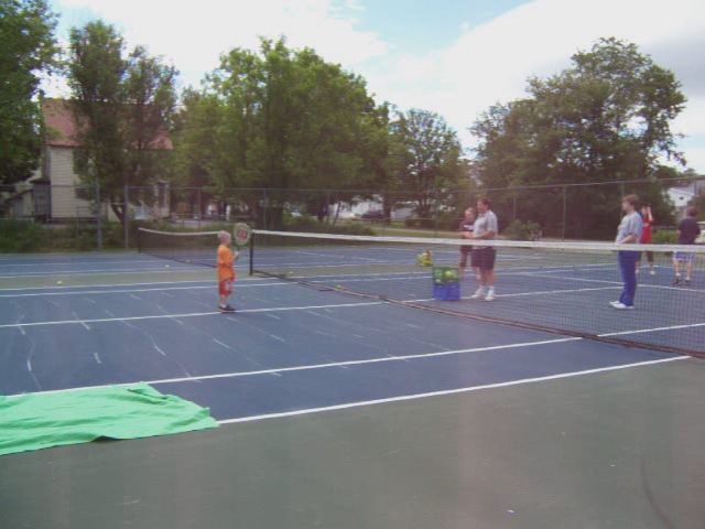 three people are on the tennis court with their rackets