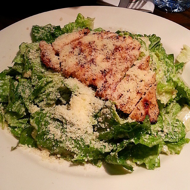 a white plate topped with greens and chicken