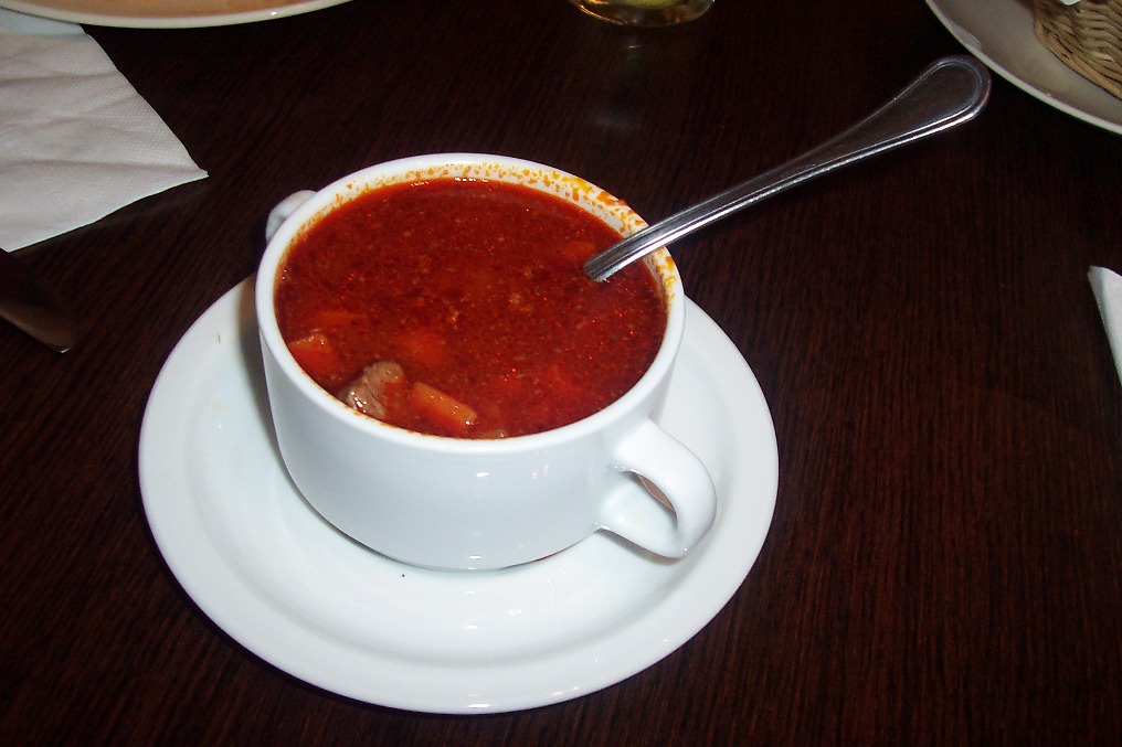a bowl of soup on top of a plate with a spoon in it