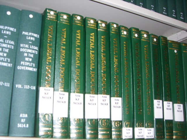 green books with numbers and names are on a shelf