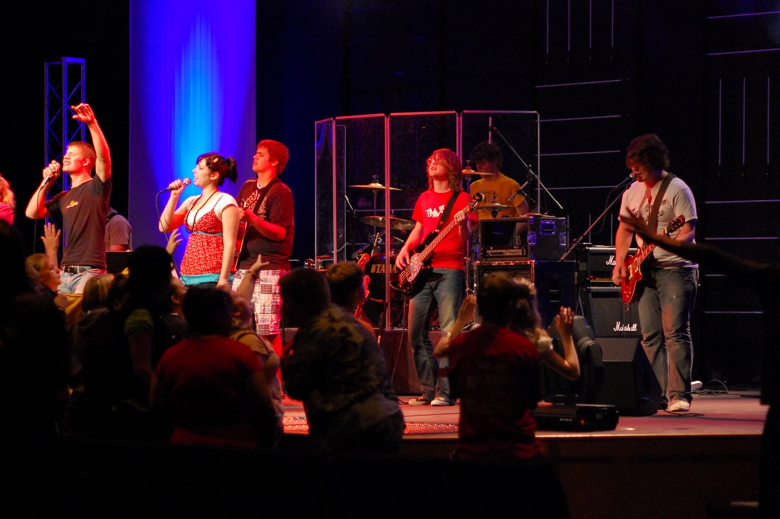 a group of people stand on stage with musical instruments