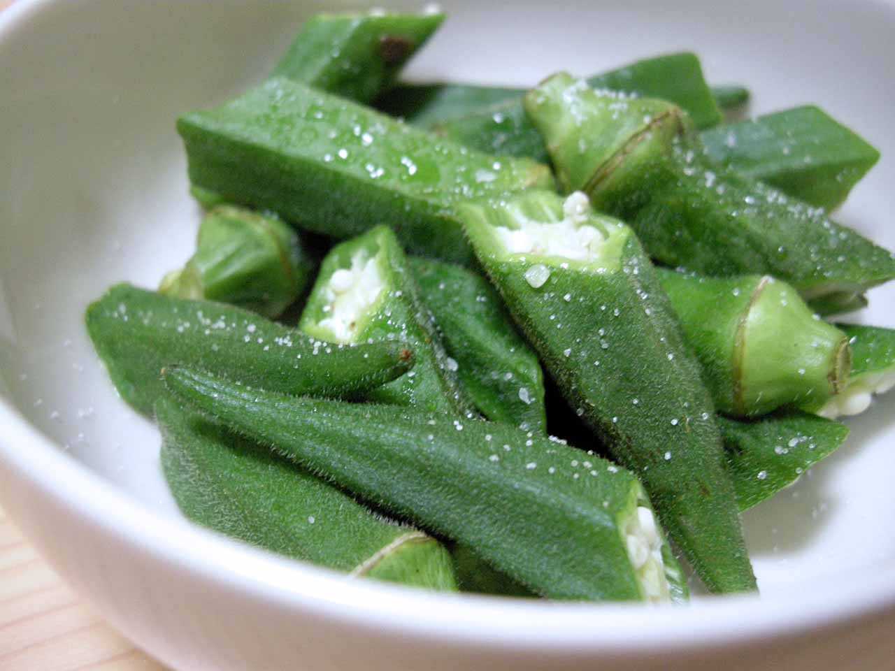 a white bowl full of sliced and chopped green beans